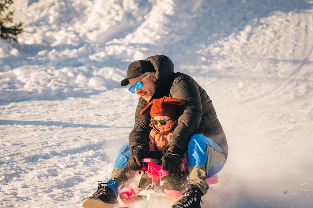 mann med liten barn på en slede på Lifjell skisenter i Bø