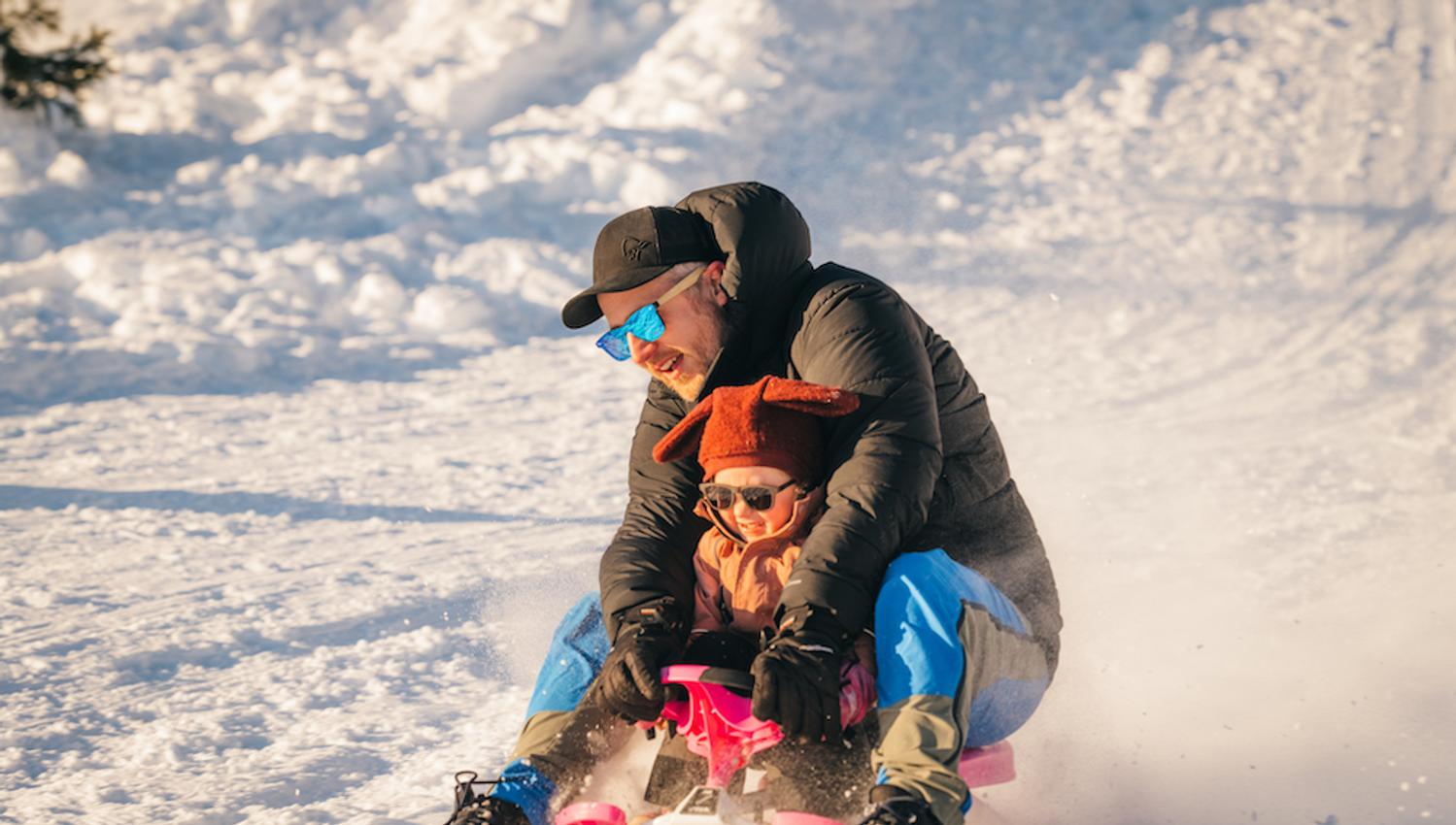 mann med liten barn på en slede på Lifjell skisenter i Bø