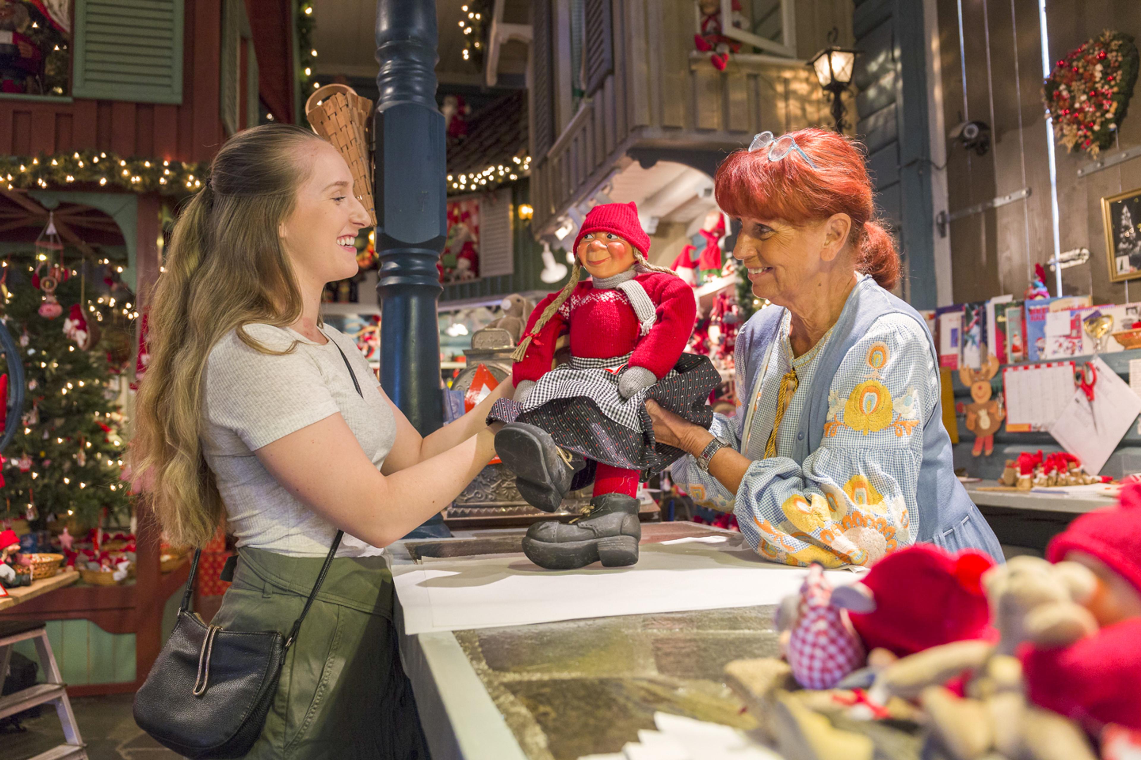 Turist kjøper nisse på Julehuset i Drøbak