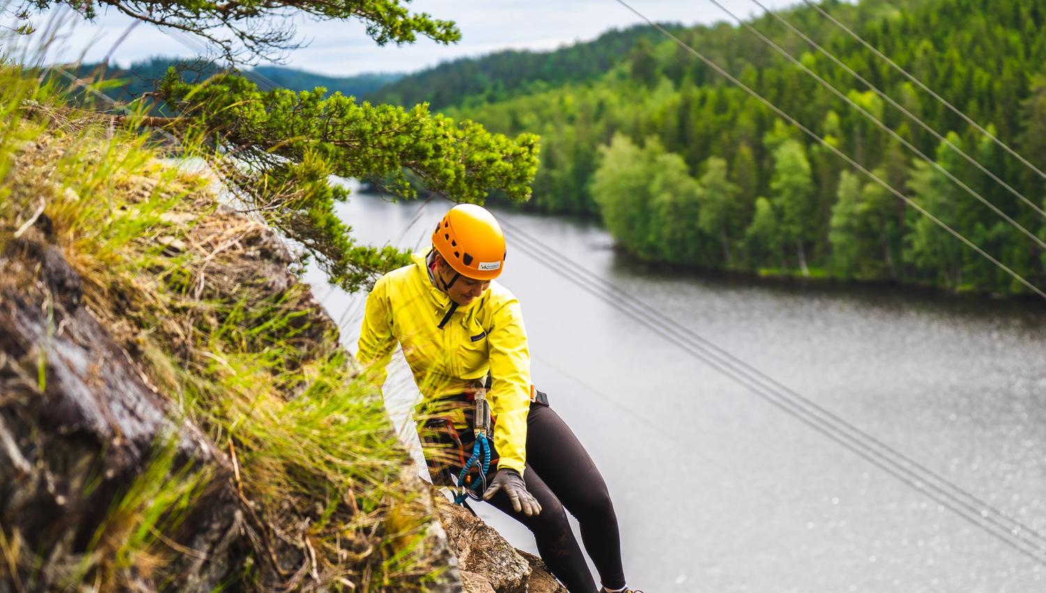 Jente i klatreløypa langs fjellet i Via ferrata Haldenkanalen
