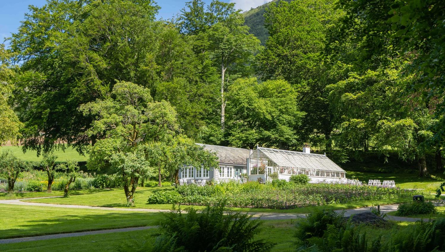 Det vakre veksthuset ved Baroniet i Rosendal omkransa av store grøntområde.