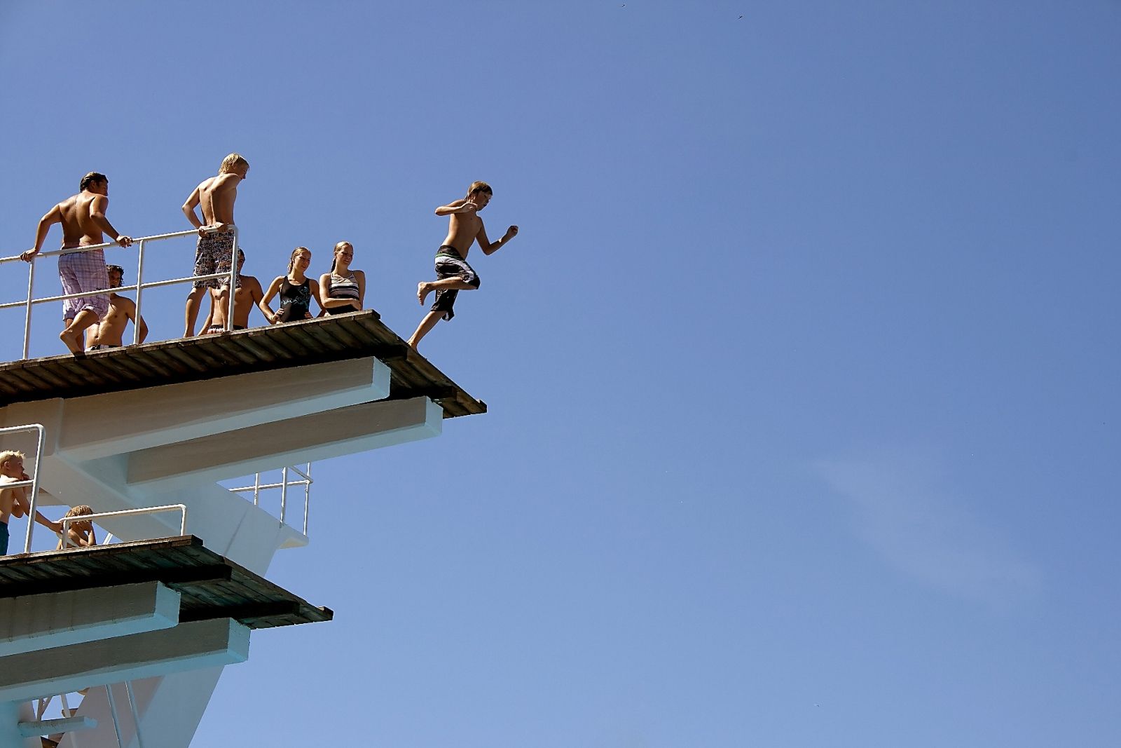 Diving tower with children jumping.
