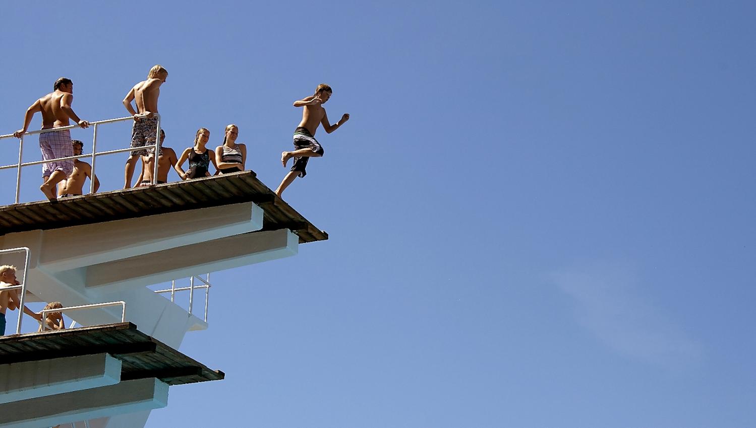 Diving tower with children jumping.