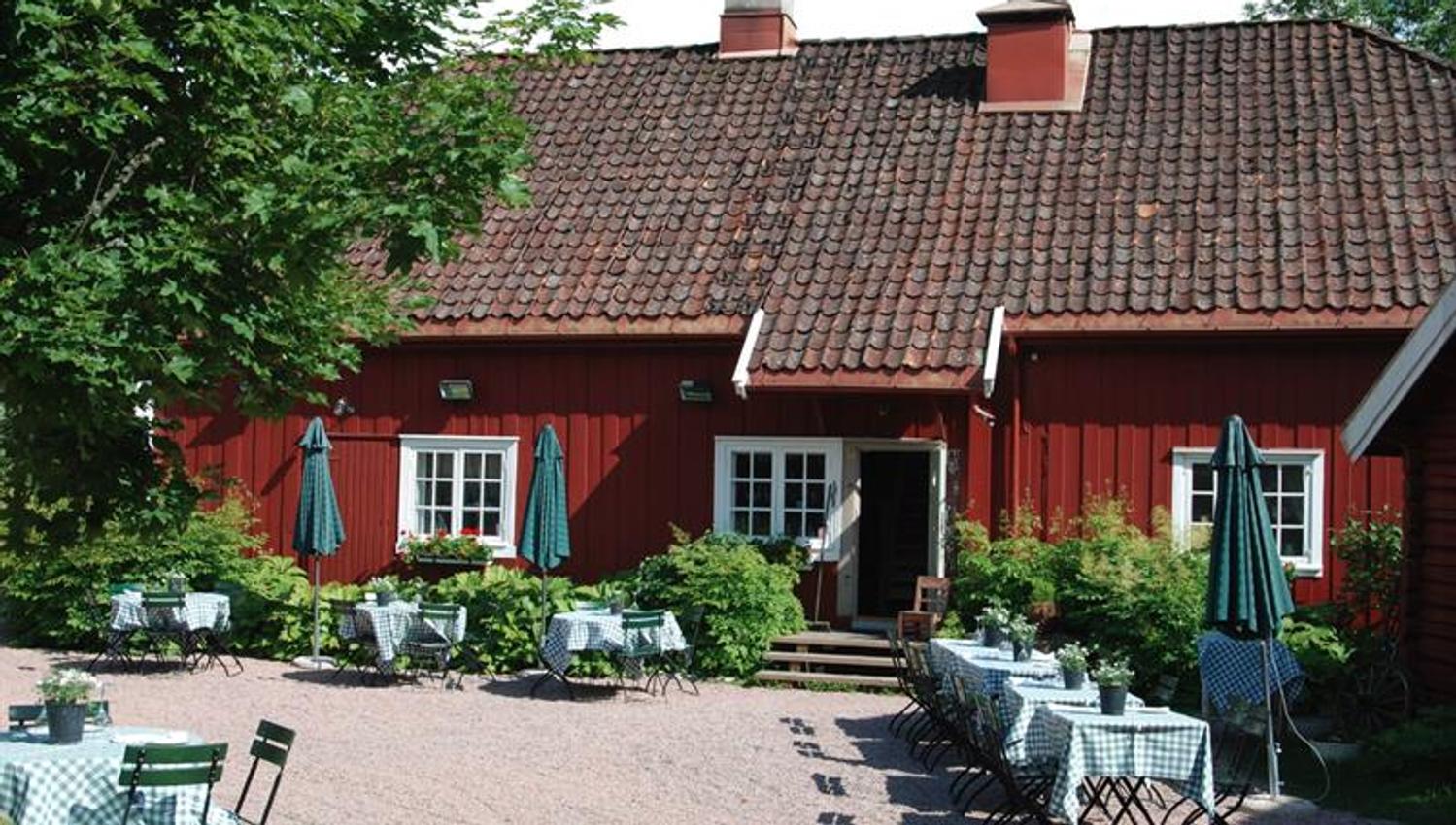 Rødt hus og dekket bord i bakhage