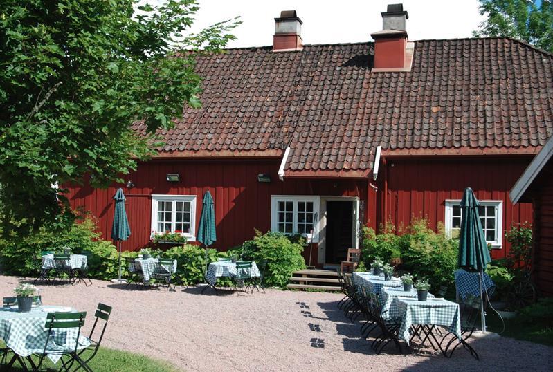 Rødt hus og dekket bord i bakhage