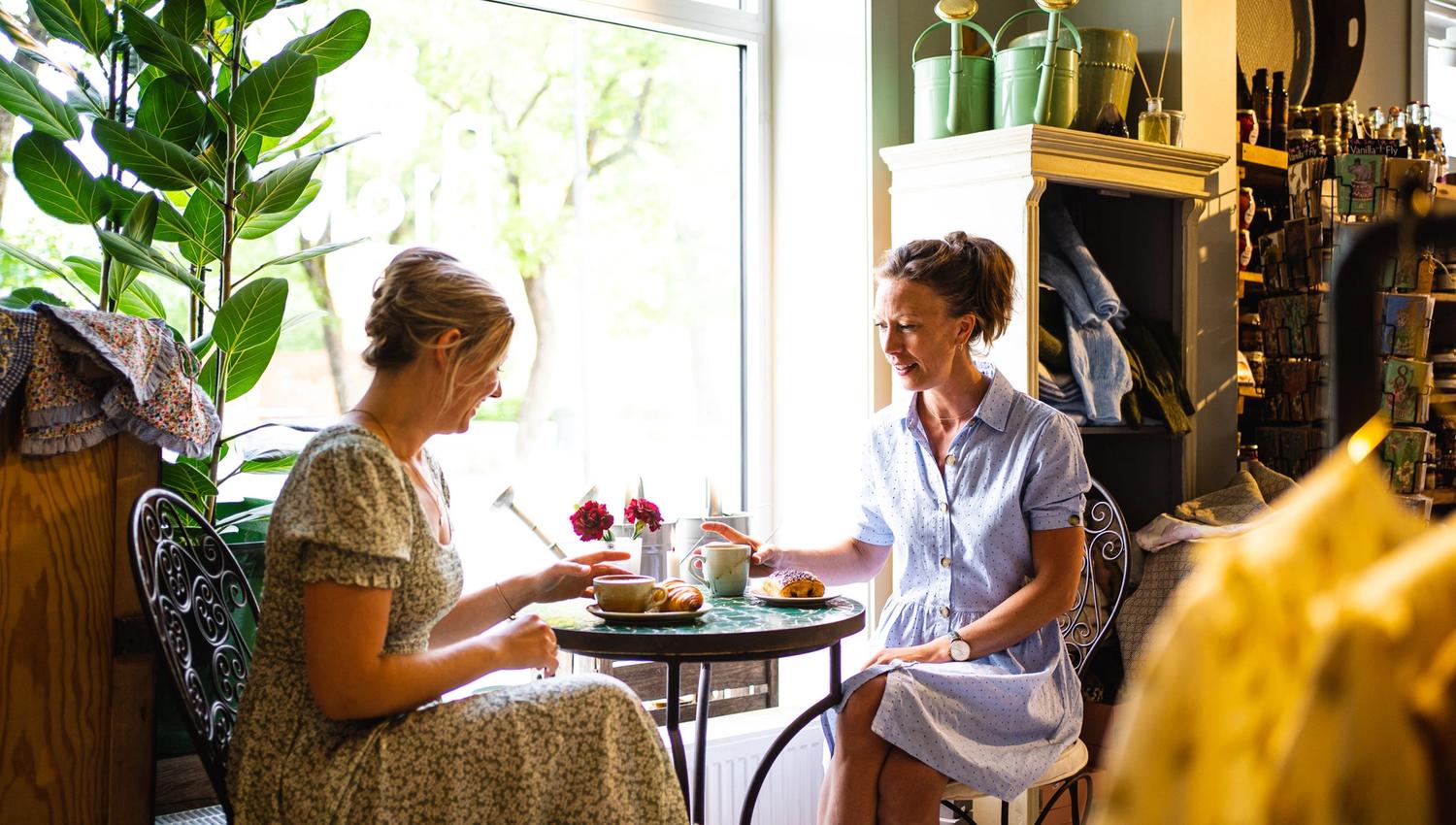 to jenter som sitter på kafe