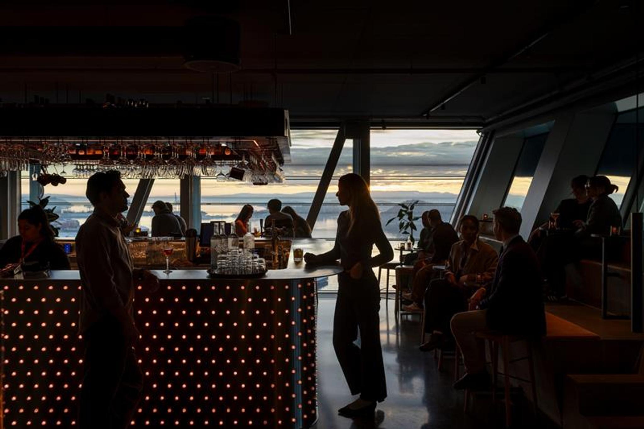 Mennesker i bar med store panoramavinduer mot Oslofjorden