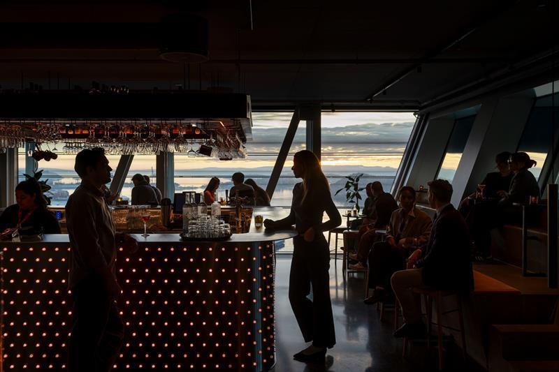 People in a bar with large panoramic windows facing the Oslofjord