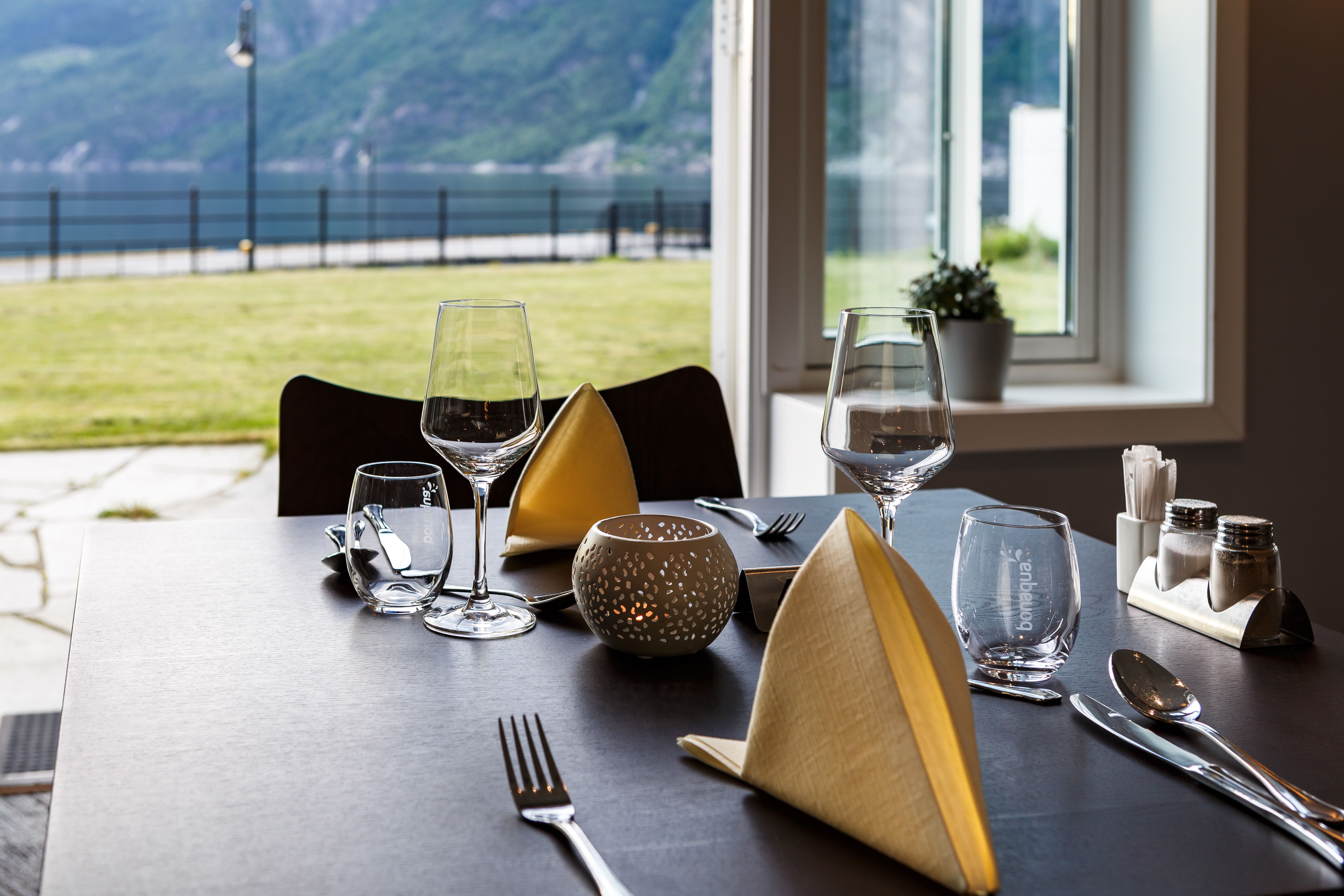 Dekket bord i restauranten, med fjordutsikt.