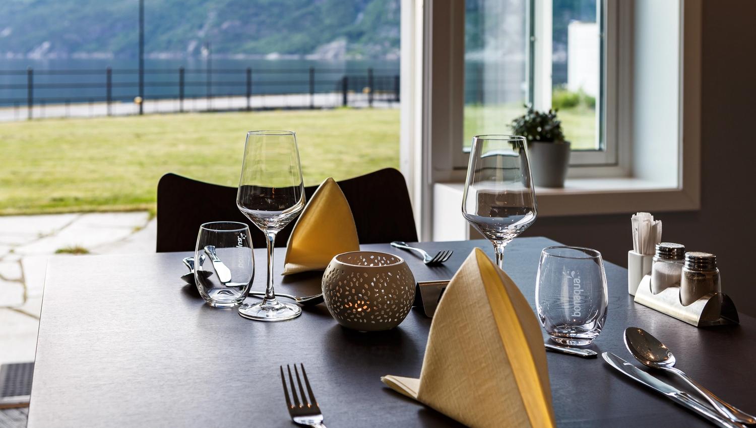 Dekket bord i restauranten, med fjordutsikt.