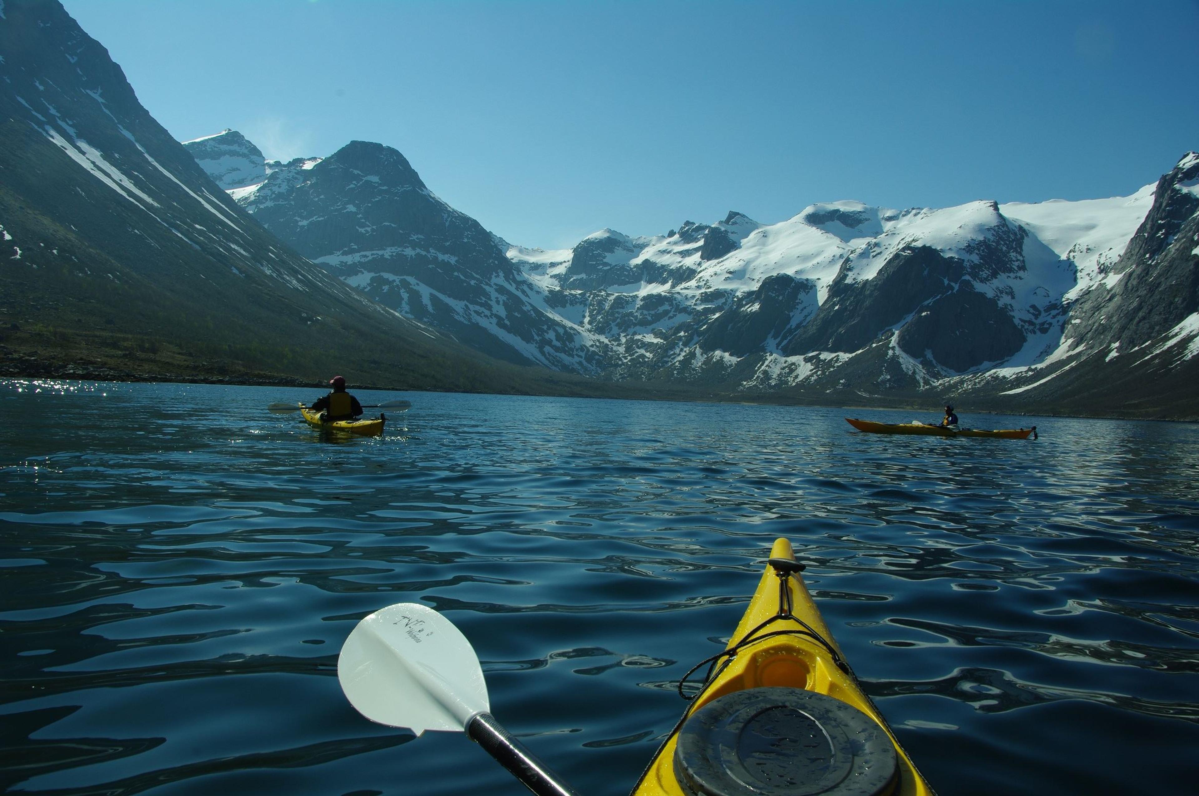 Kayak inside a fjord with tall mountain peaks around