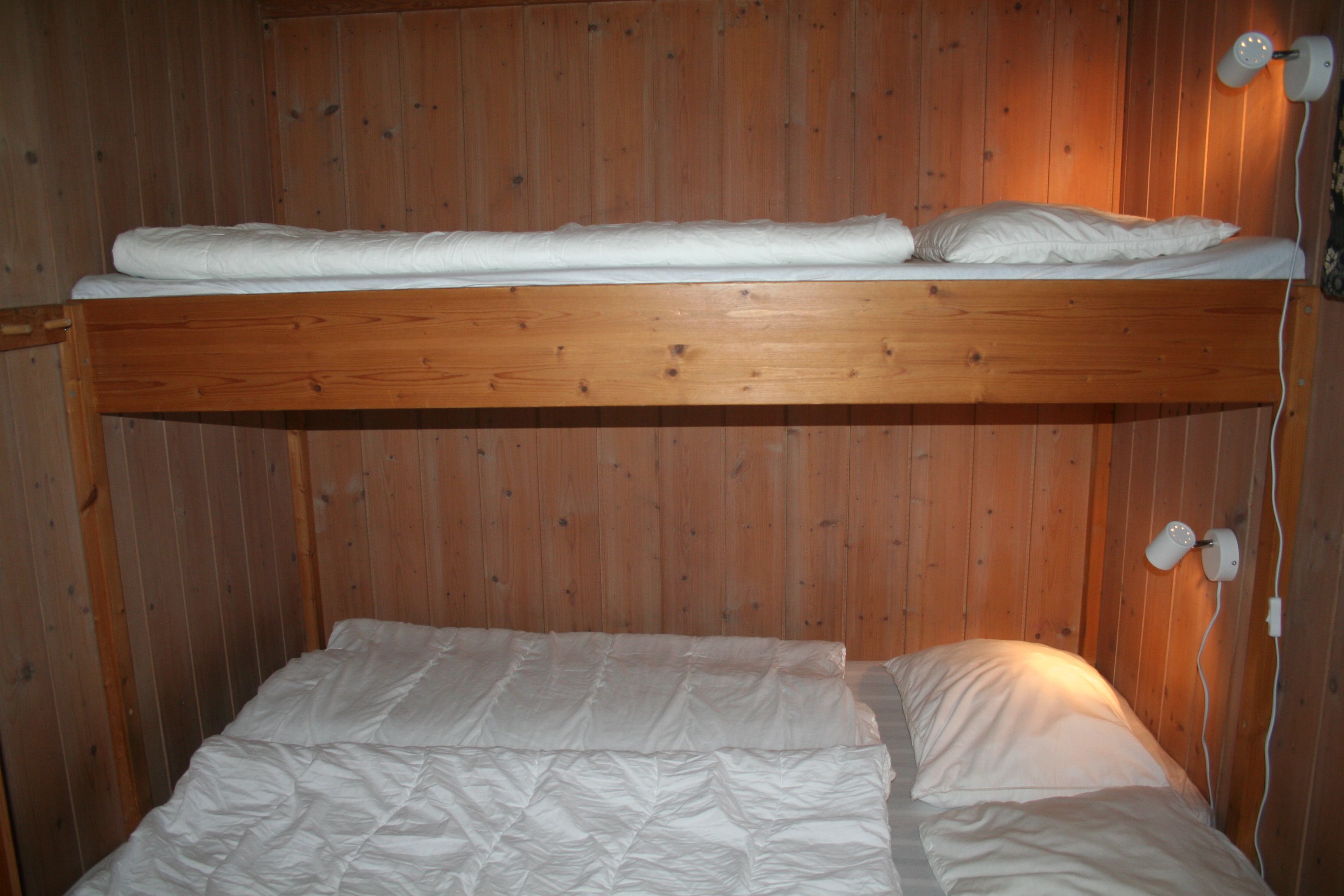 Koseleg soverom med køyeseng og trepanel i hytte på Hardanger Feriesenter.