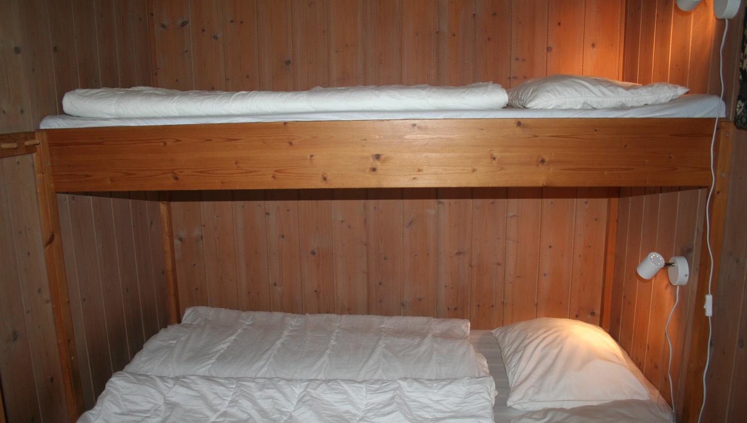 Koseleg soverom med køyeseng og trepanel i hytte på Hardanger Feriesenter.