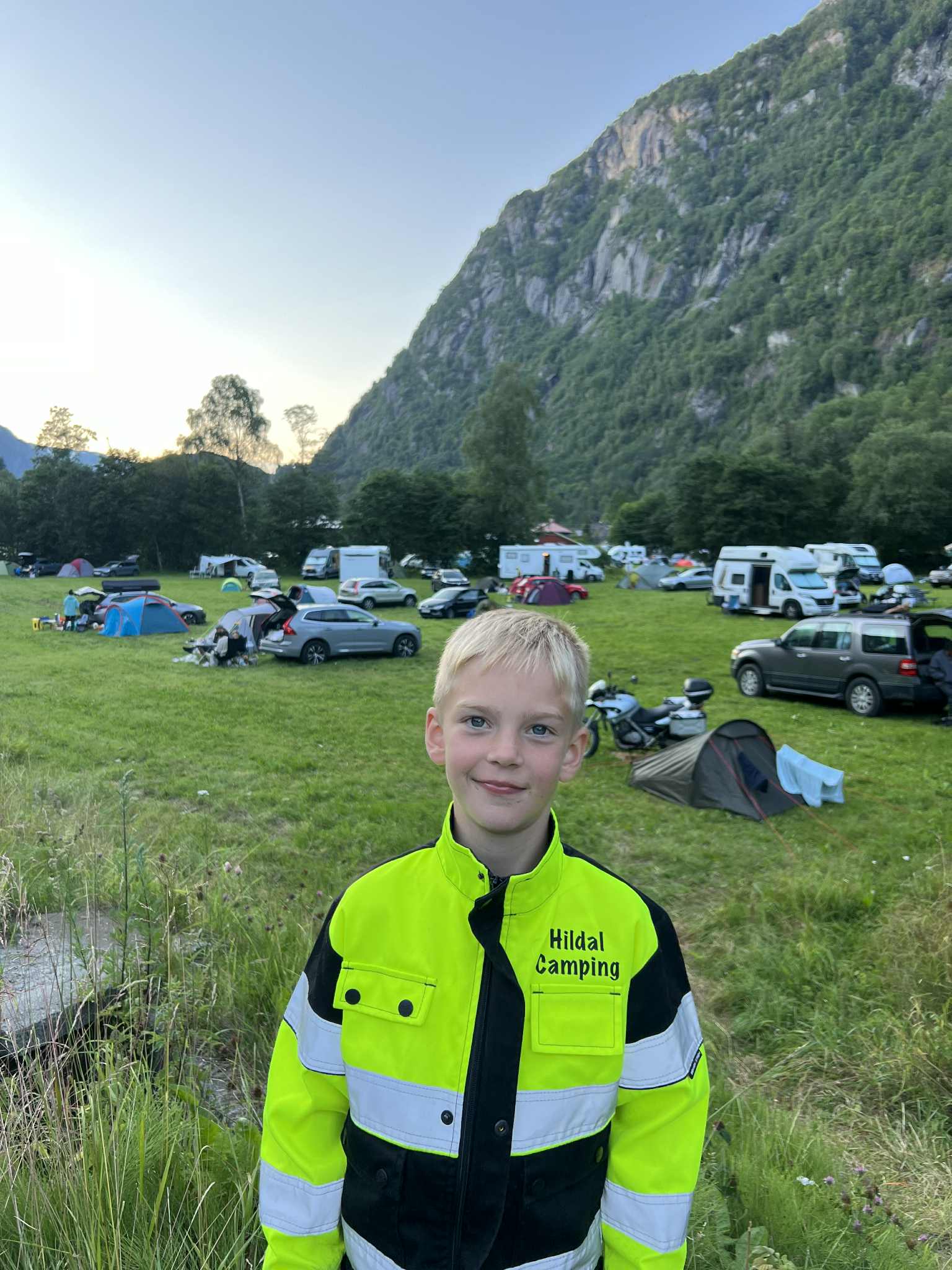 Elvebreidd nær Hildal Camping med utsikt mot skog, fjell og fossefall i Hardanger.