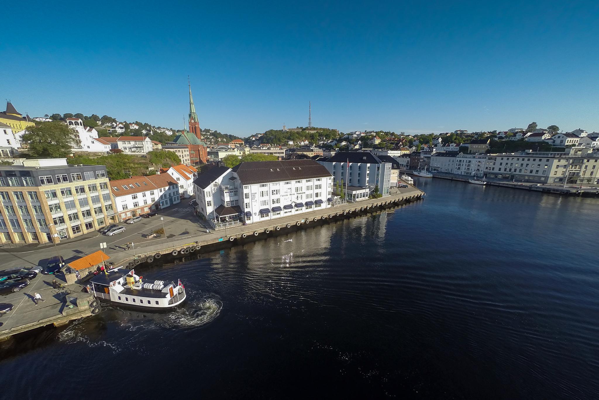Clarion Hotel Tyholmen sett fra luften med fergeleiet på Tyholmen til venstre. Ferga Kolbjørn legger akkurat til kai.