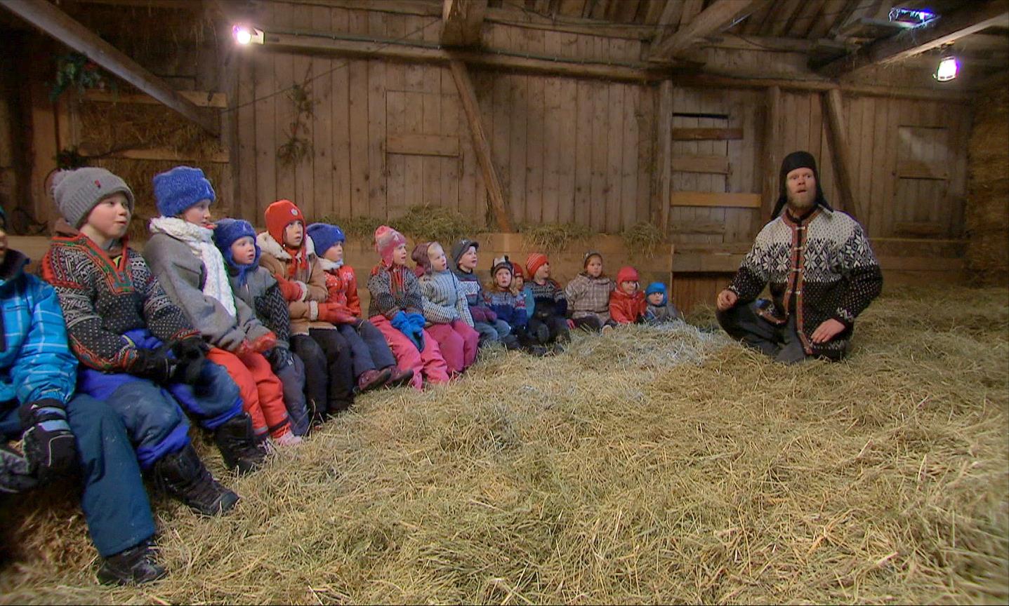Child and man sit in the barn in the hay