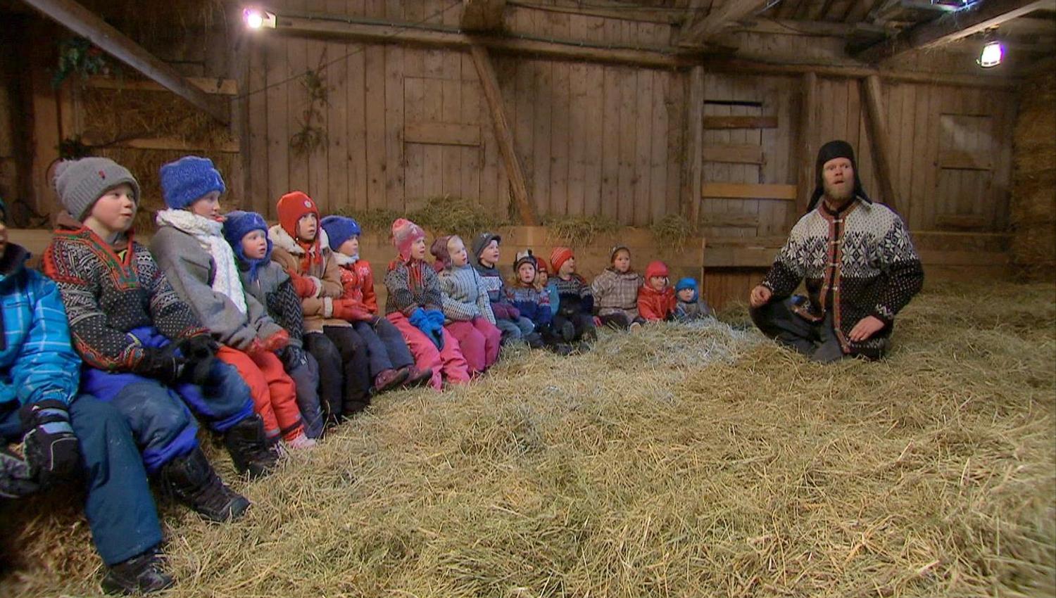 Child and man sit in the barn in the hay