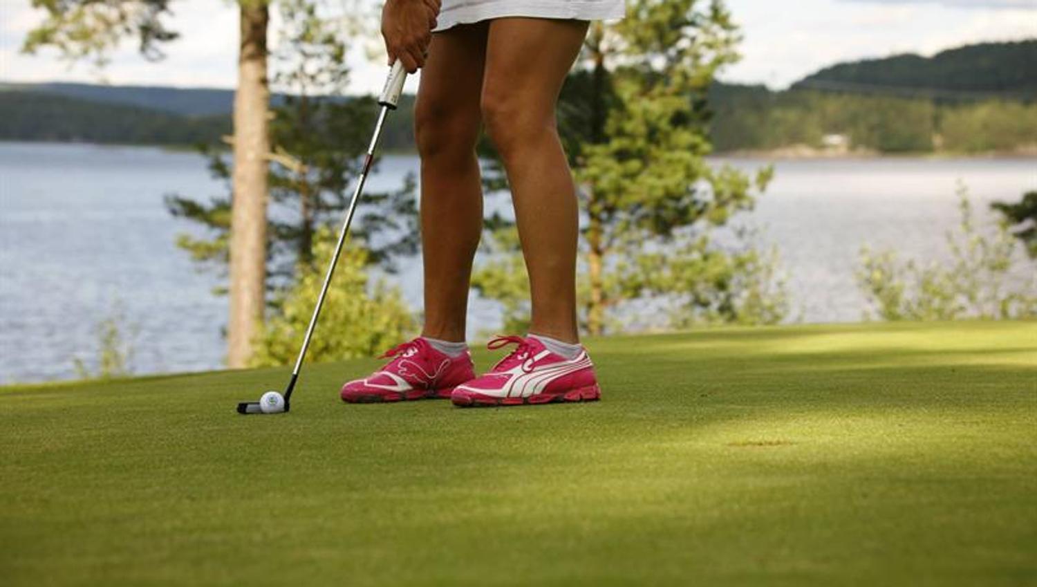 Kvinne som spiller golf på Skjeberg Golfklubb. Foto.