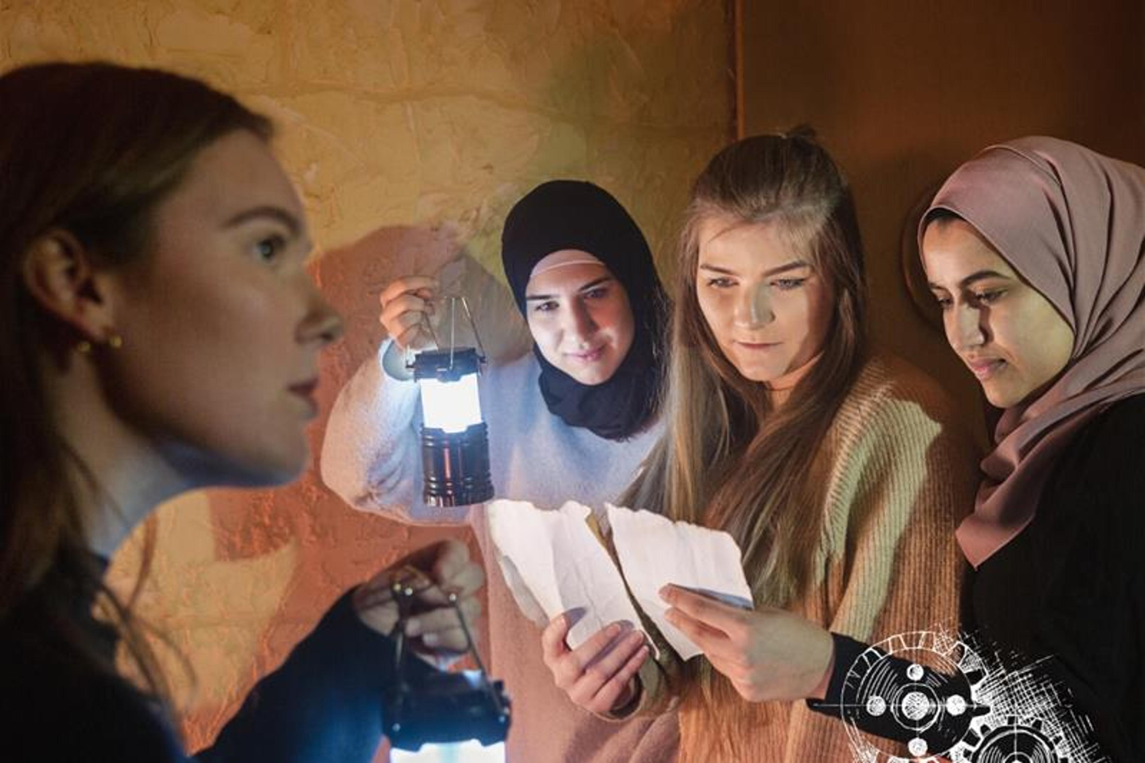 a group of women with lanterns in their hands read something written on two sheets of paper