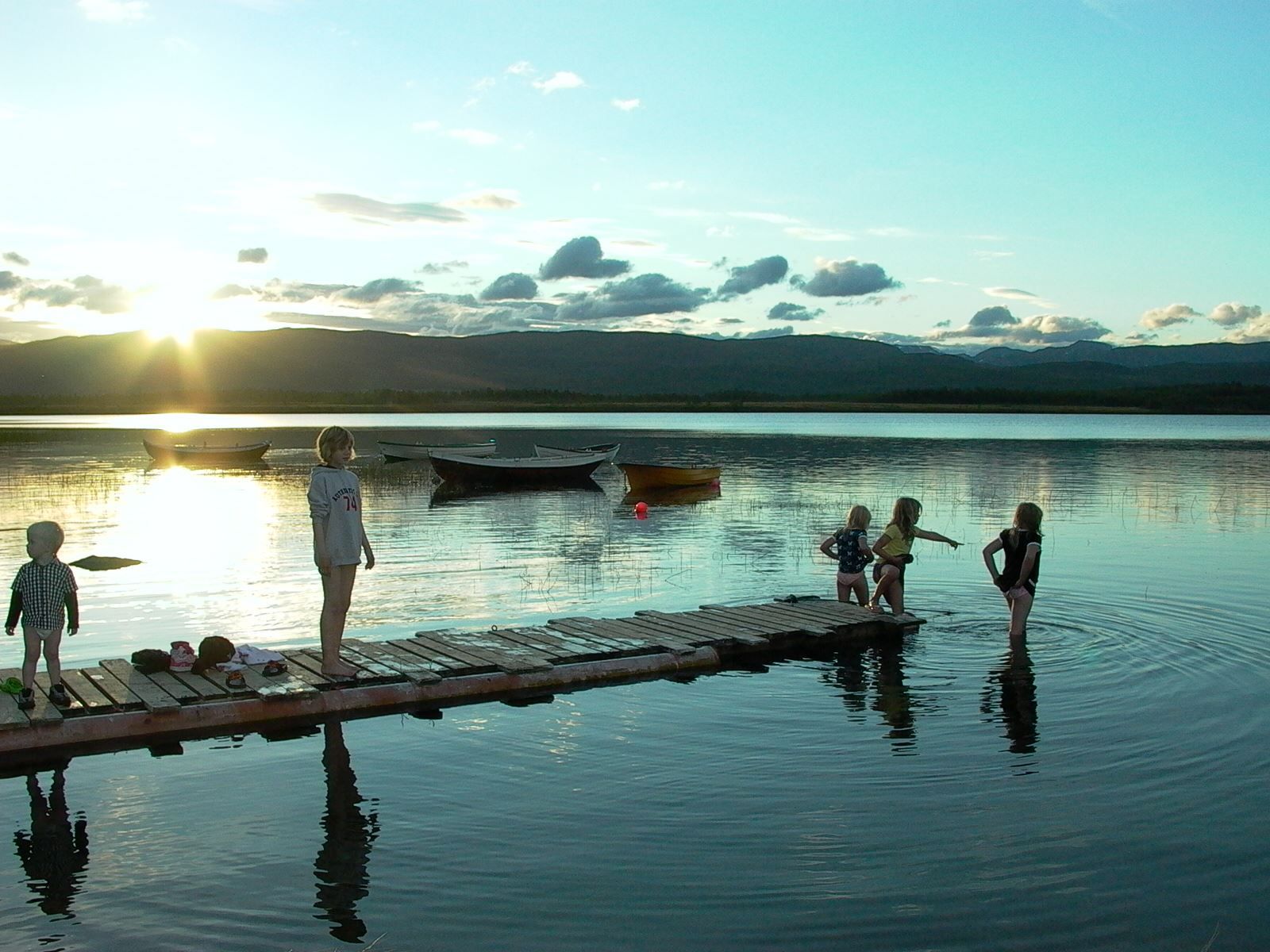 children playing in the lake in the midnight sun