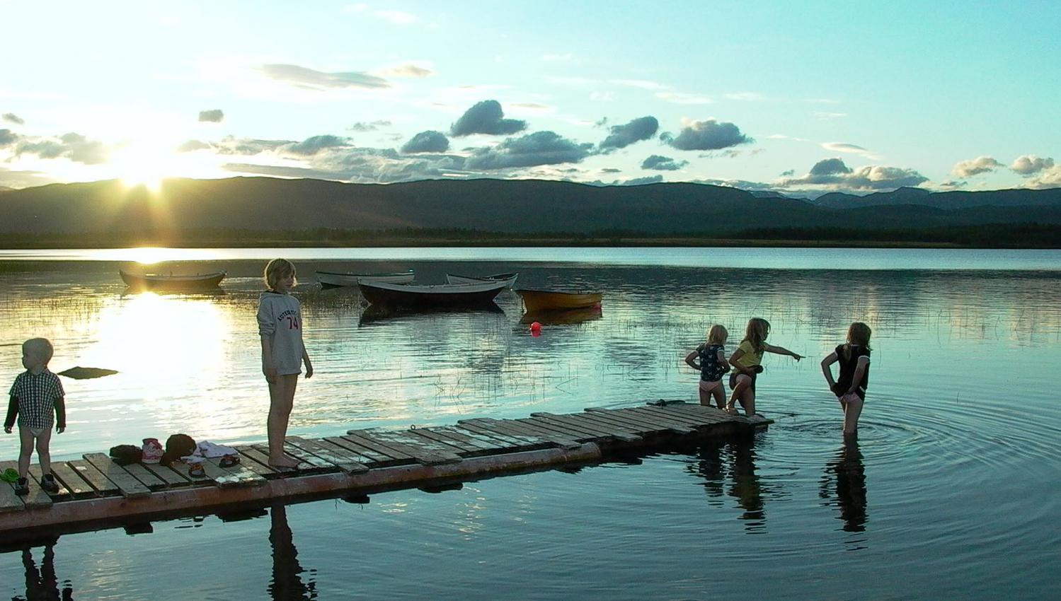 children playing in the lake in the midnight sun