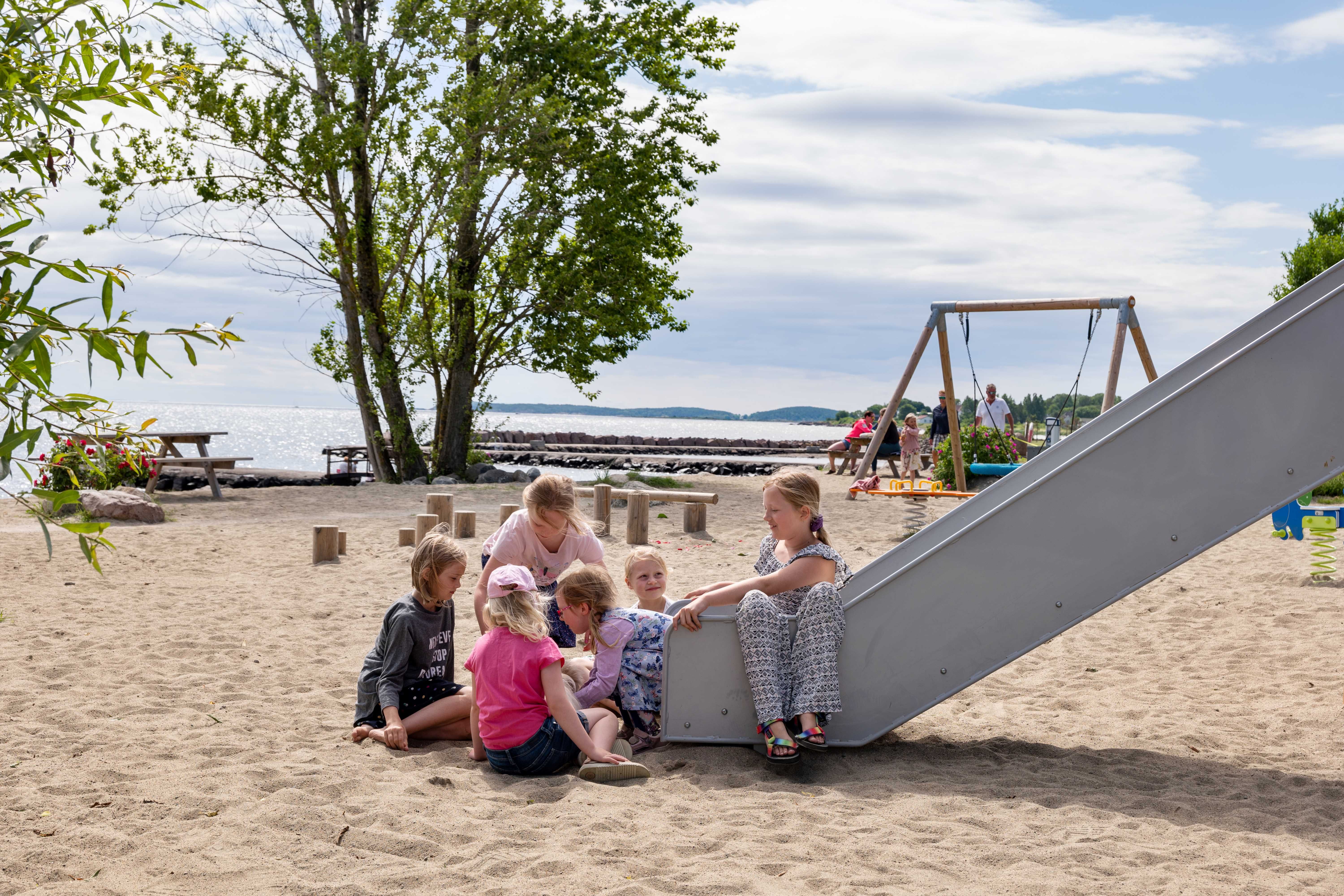 Barn leker på lekeplass ved stranda