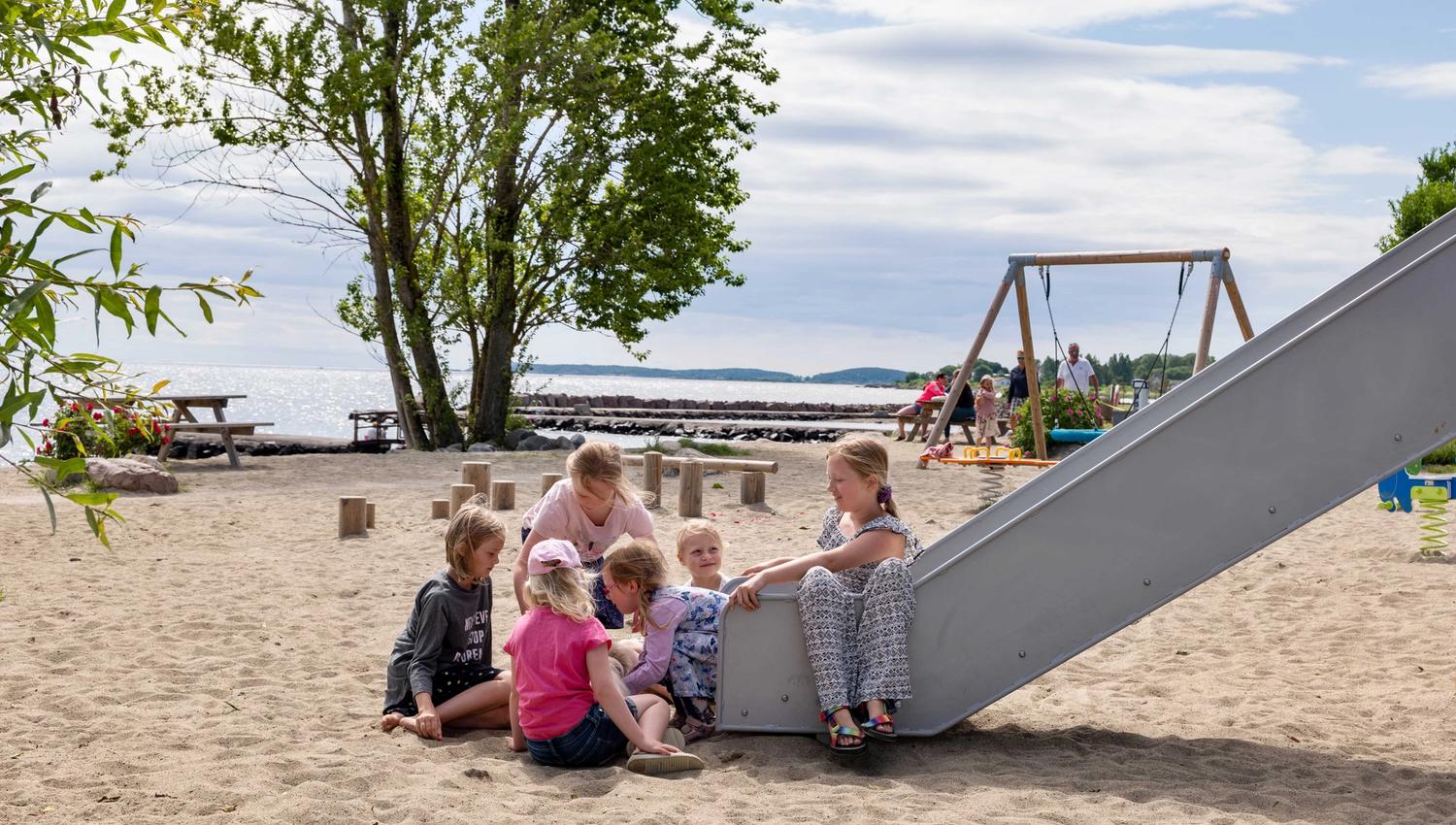 Barn leker på lekeplass ved stranda