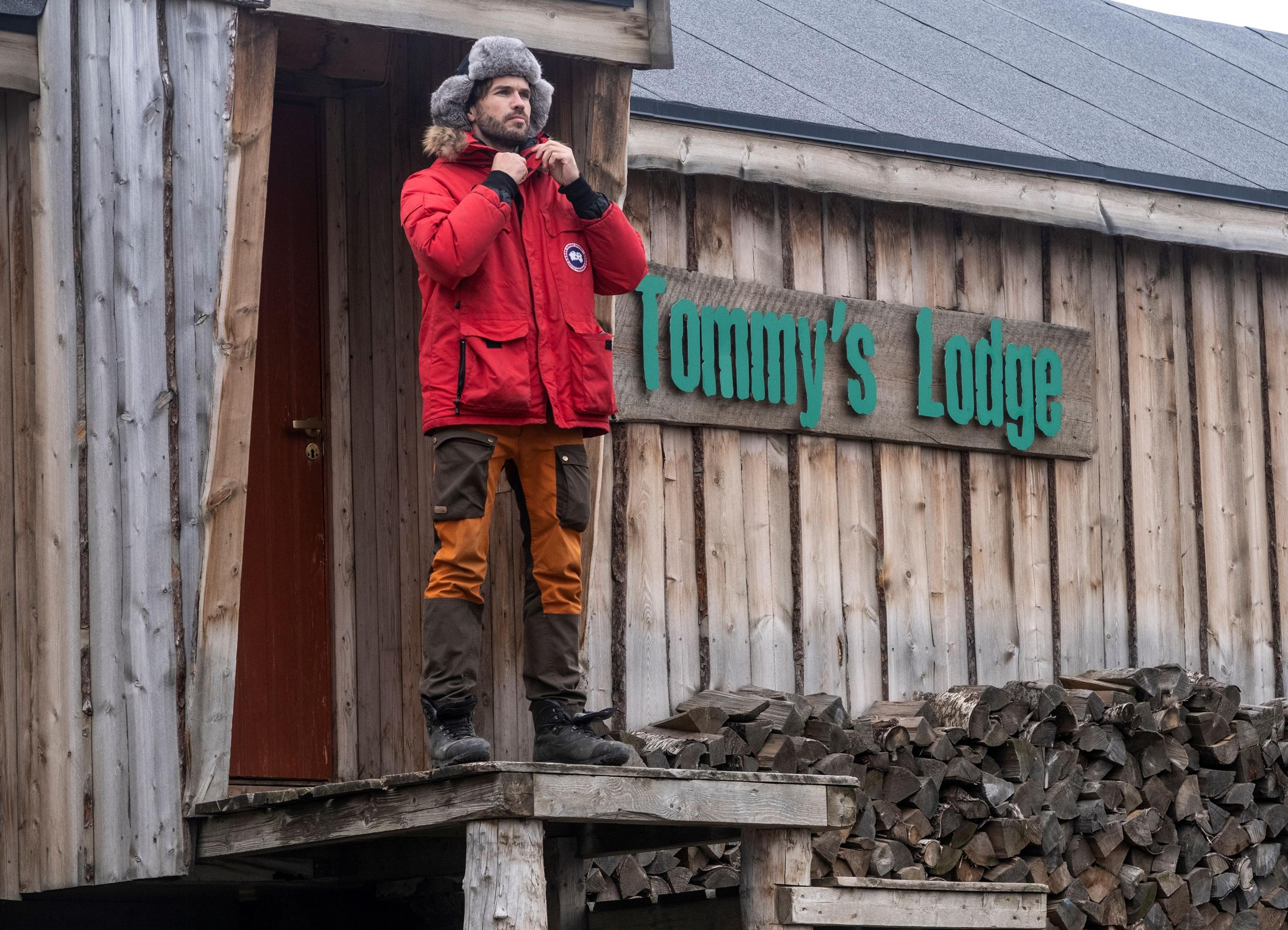 A person standing on some stairs in front of Tommy's Lodge