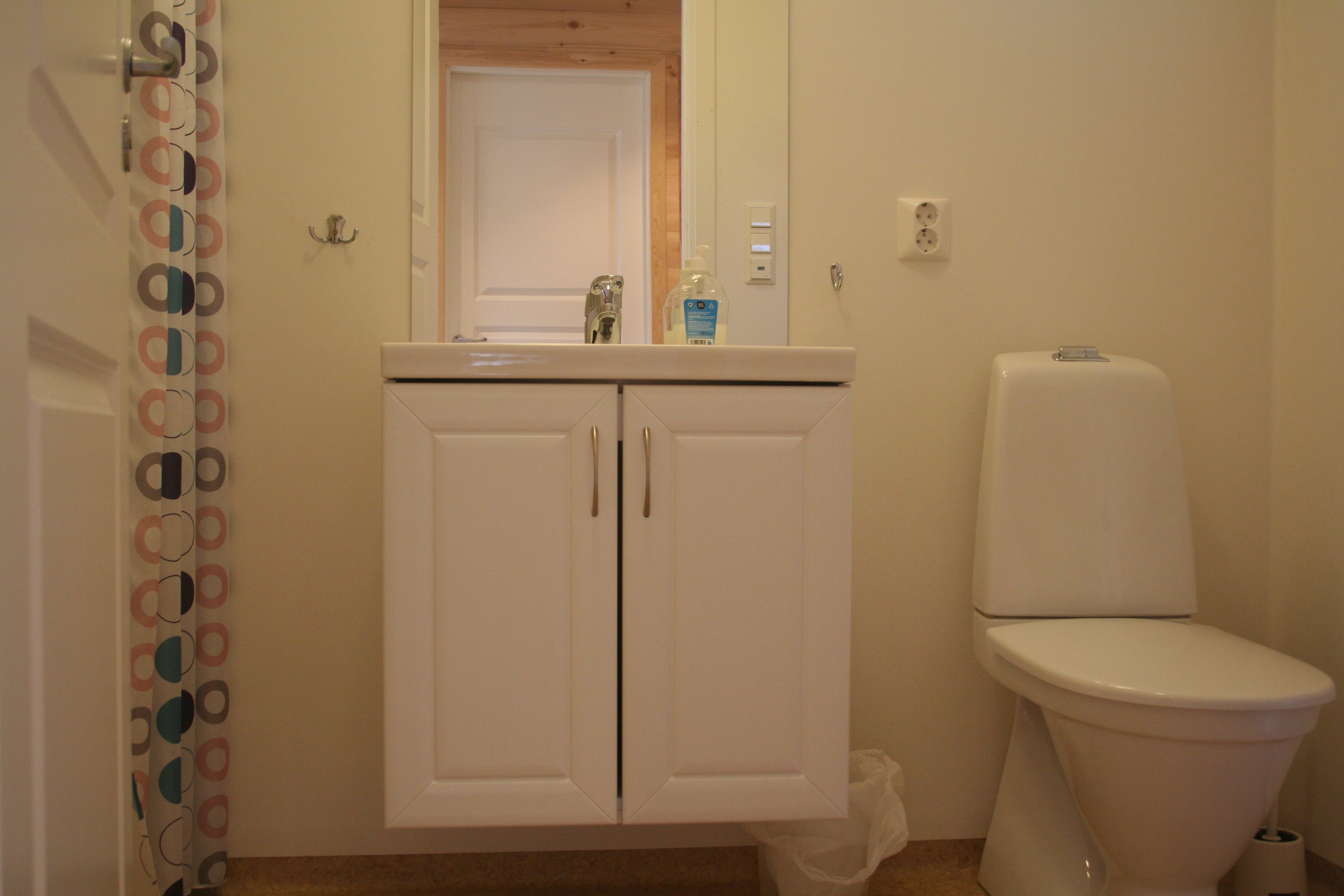 Reint og moderne bad med servant, spegel og toalett på Vågen Rom og Hytteutleige.