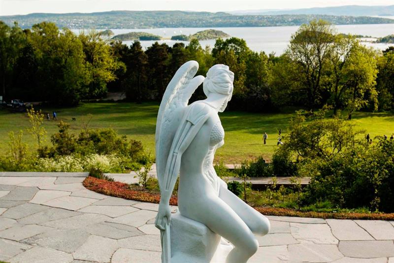 Sculpture of an angel sitting on a rock.