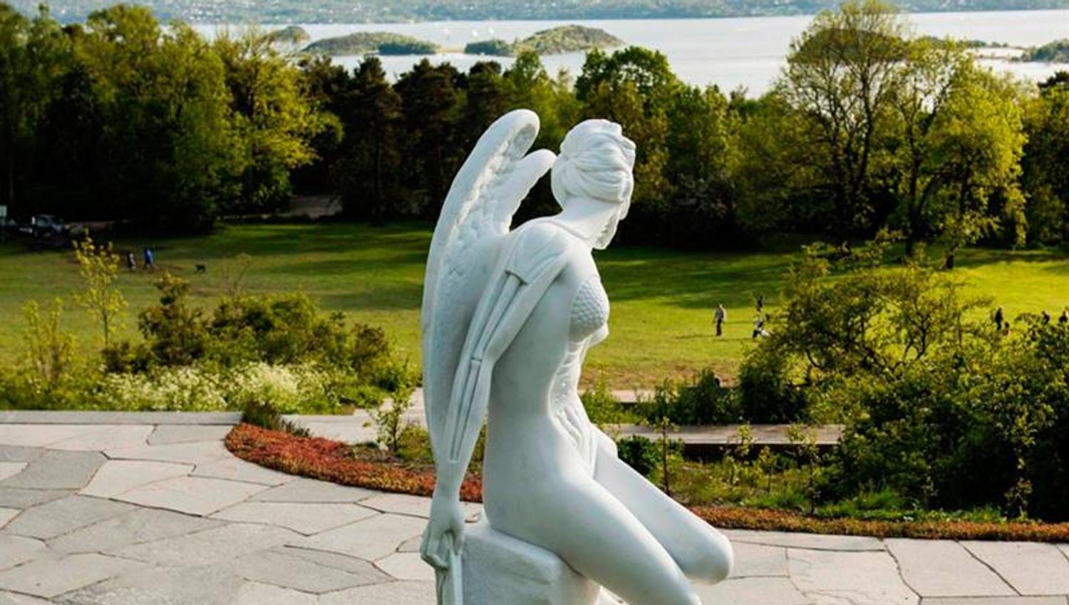 Sculpture of an angel sitting on a rock.