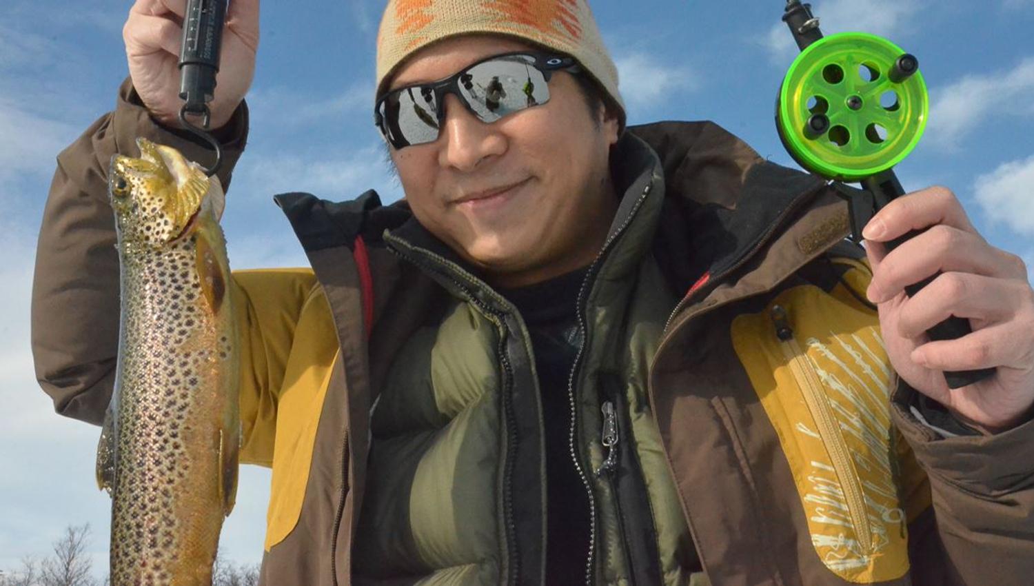 A guest holding a fish they have caught