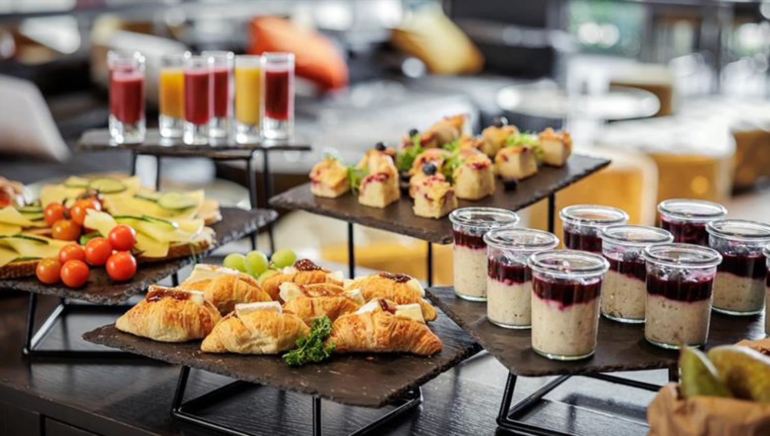 Delikat oppsatt buffet med småretter, desserter og servering til møte eller arrangement.