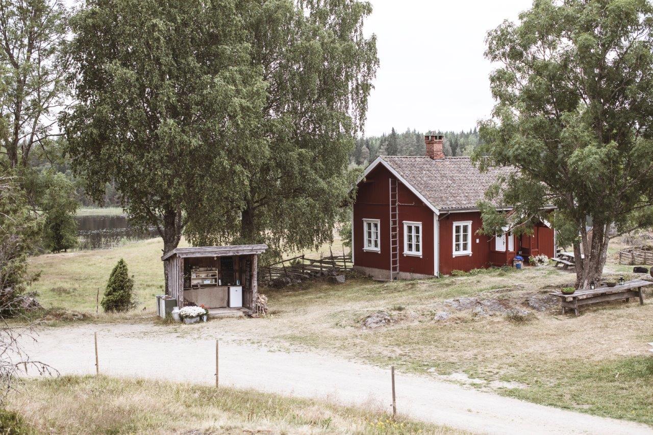 et rødt gårdshus og et gårdsutsalg