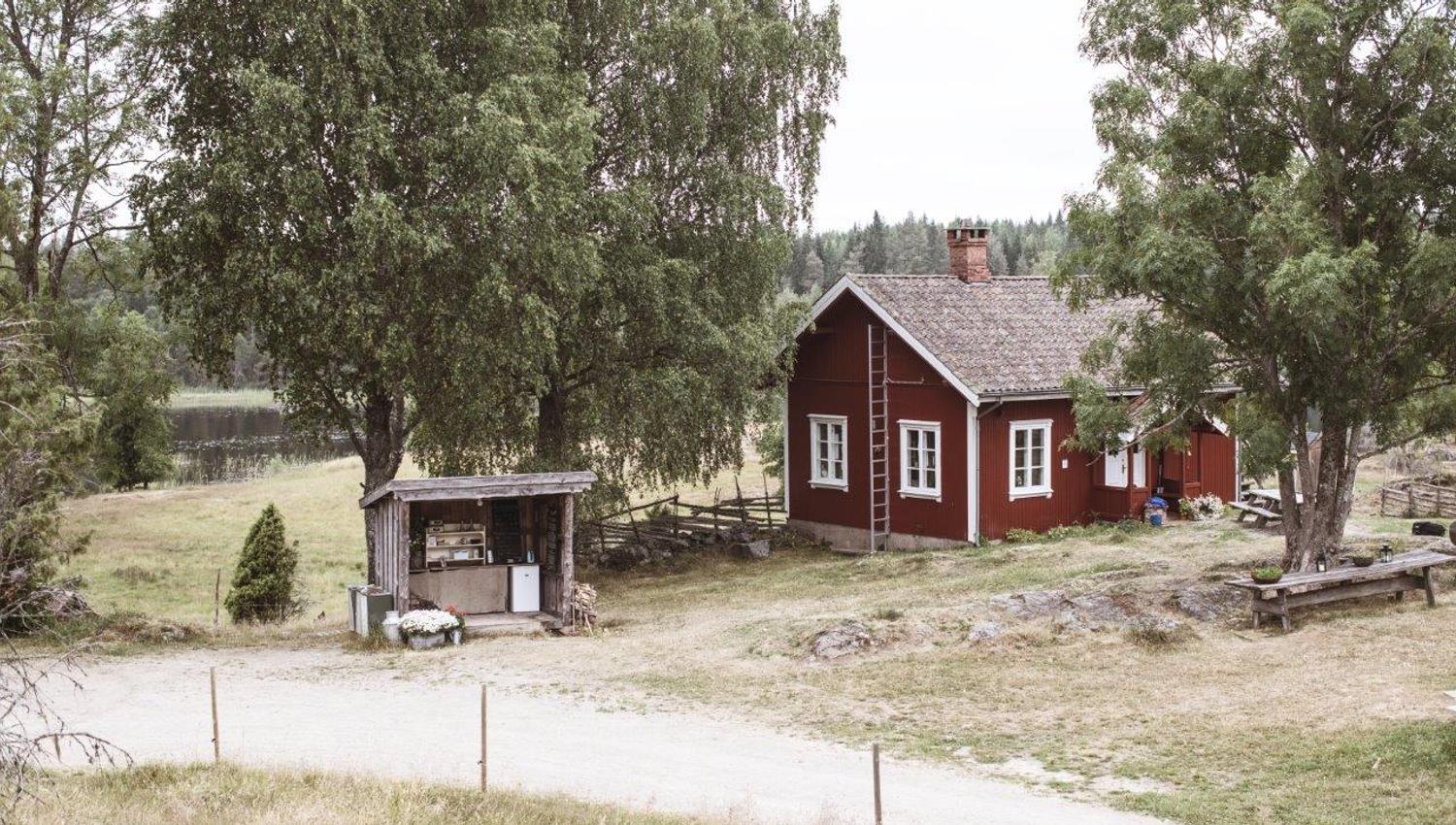 et rødt gårdshus og et gårdsutsalg