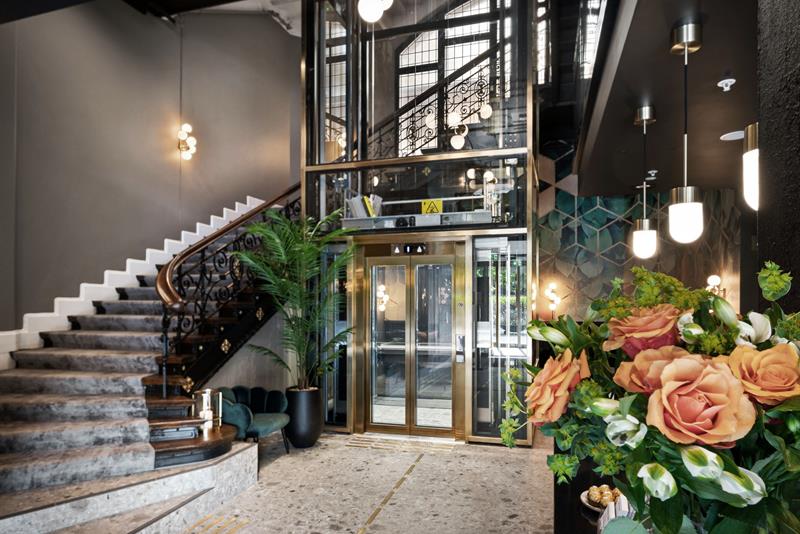 Staircase with elevator and potted plants.