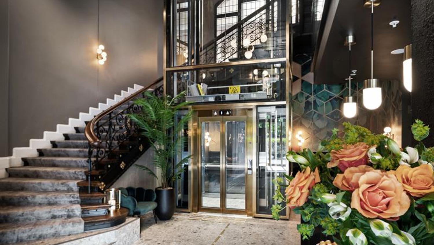 Staircase with elevator and potted plants.