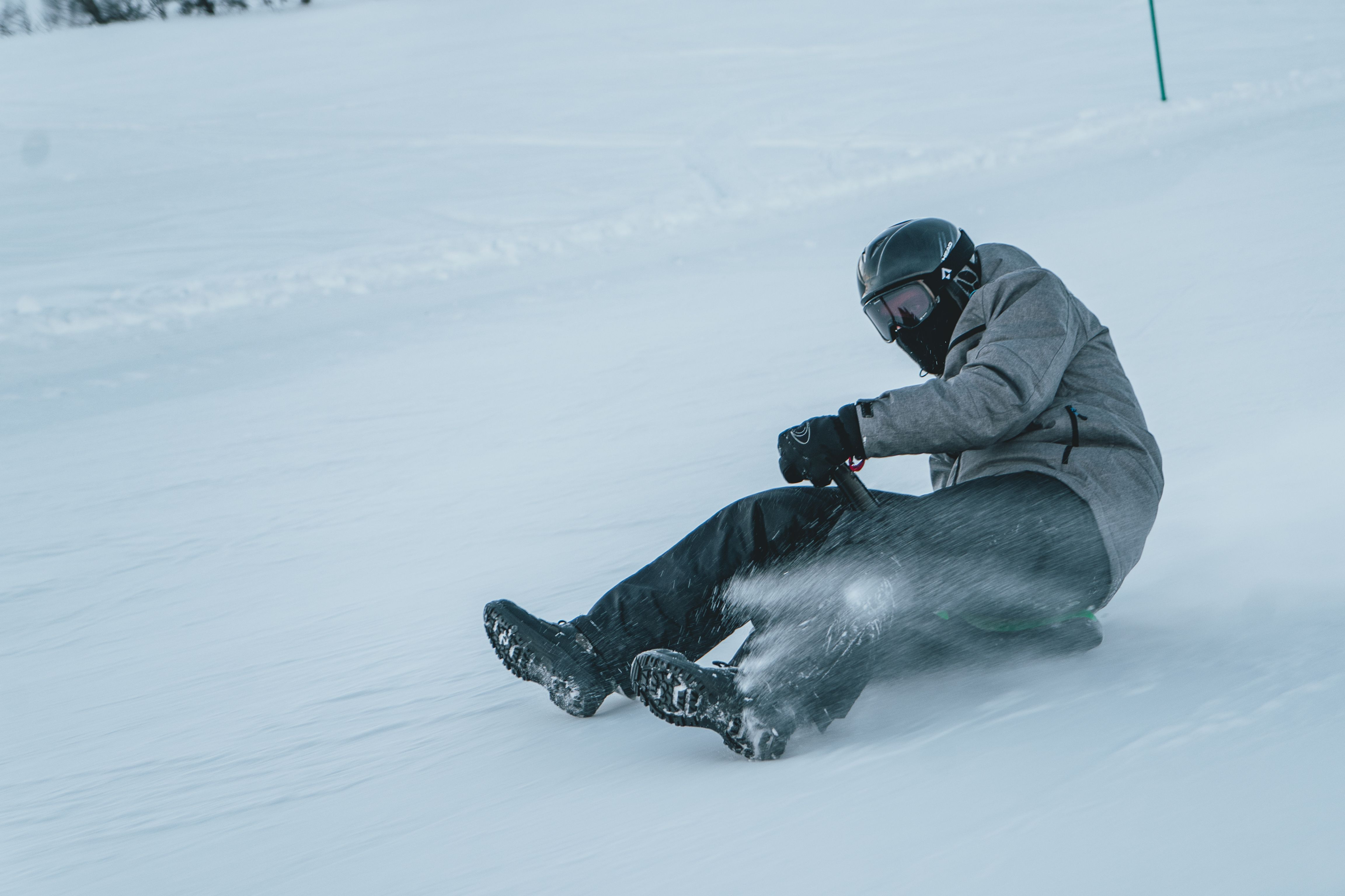 Person på akebrett i høy fart nedover bakken, bilde