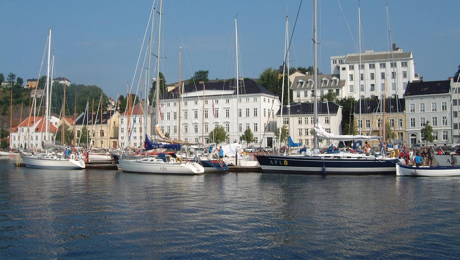 Arendal gamle rådhus fra sjøen med mange seilbåter foran