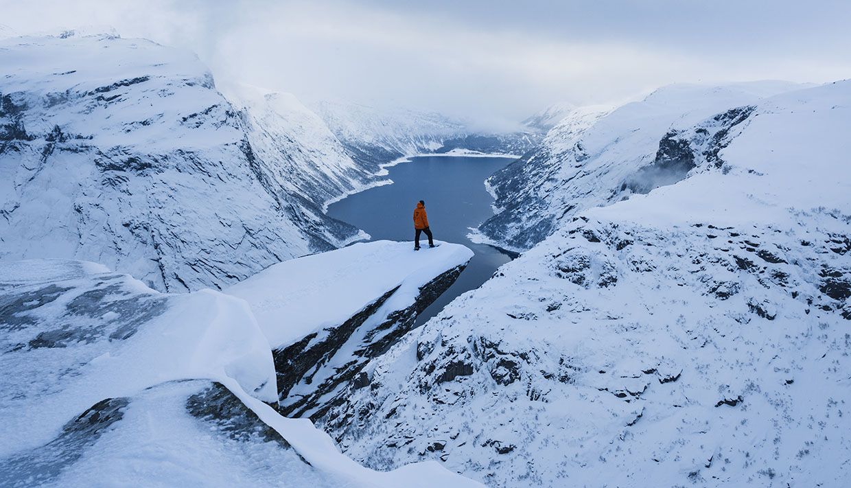 Deltakarar med snøsko i mjukt kveldsslys over fjellplatået ved Trolltunga.