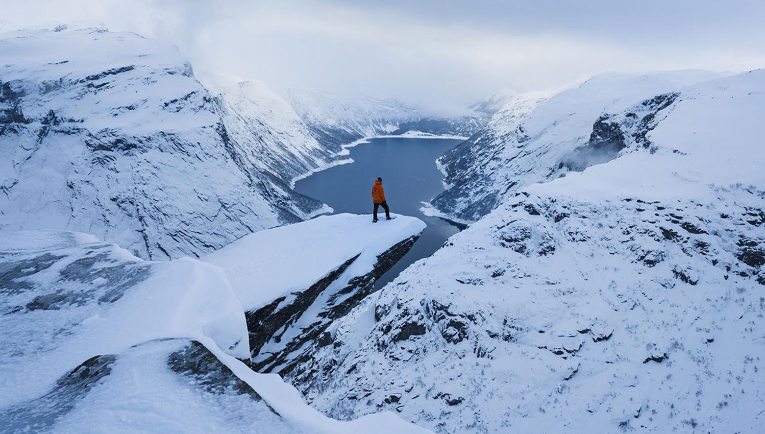 Deltakarar med snøsko i mjukt kveldsslys over fjellplatået ved Trolltunga.