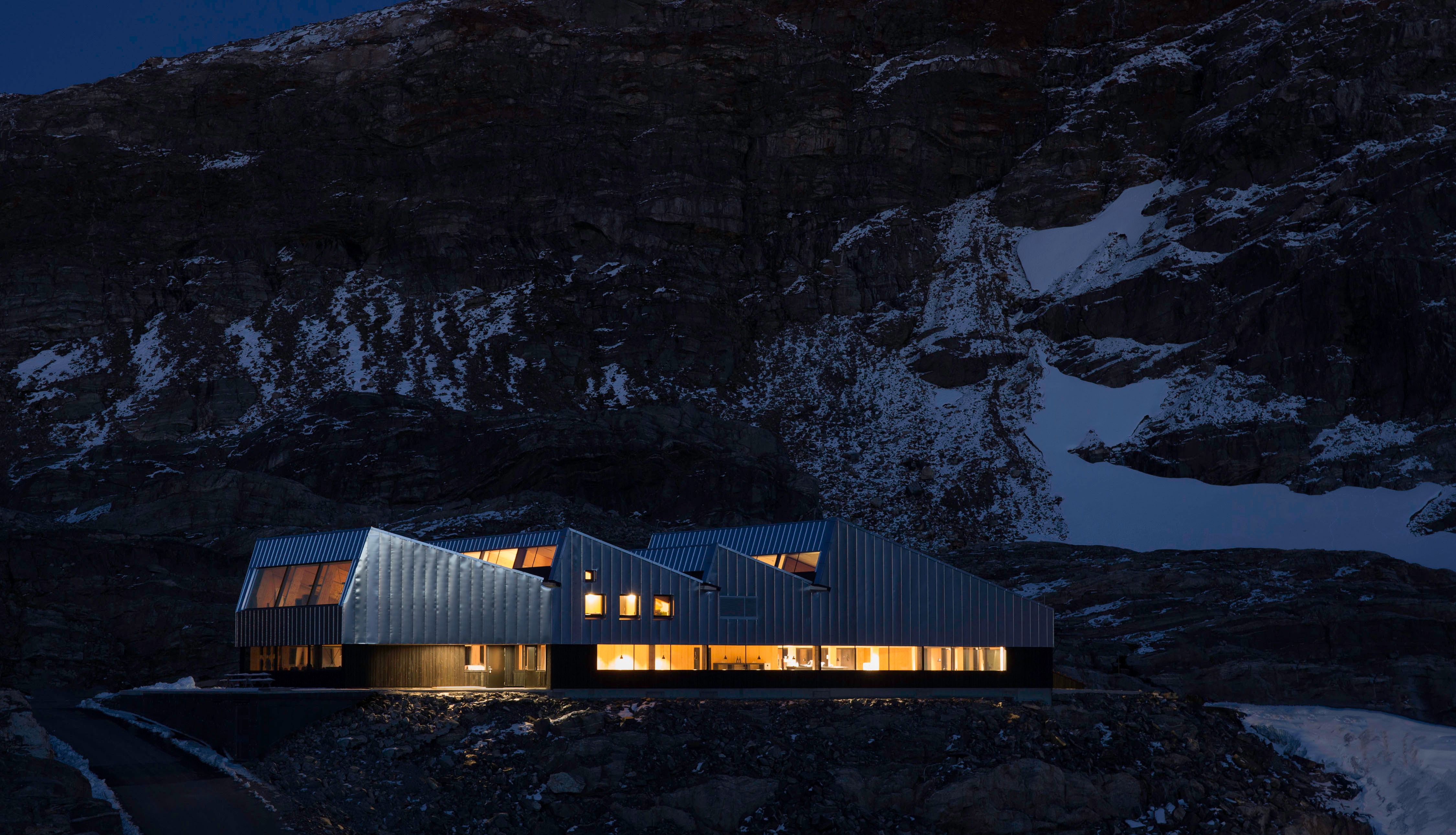 Fonna1199 glows in the night, with the snowy landscape and dark mountains as a backdrop