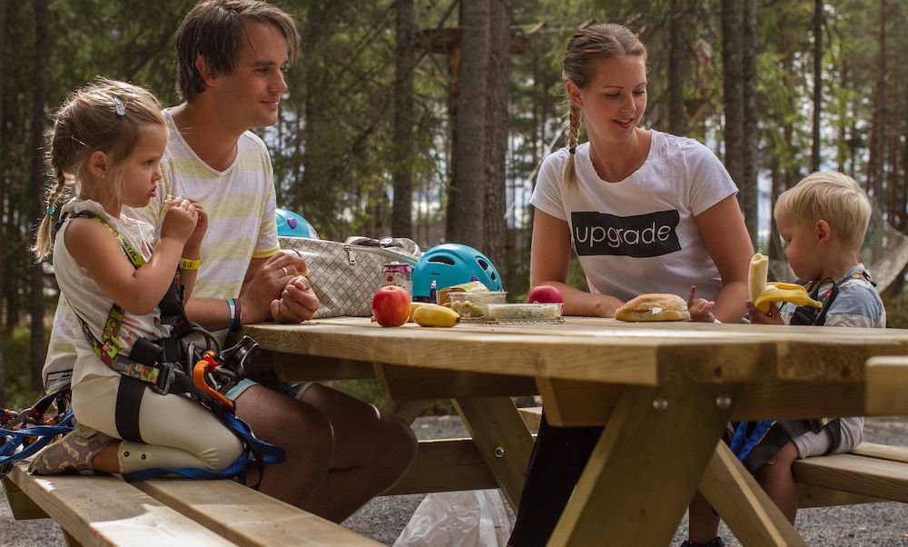 family sitting and eating at the climbing park Høyt og Lavt in Bø in Telemark 