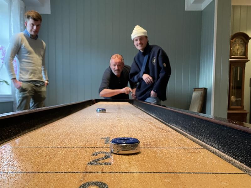 Menn spiller shuffleboard