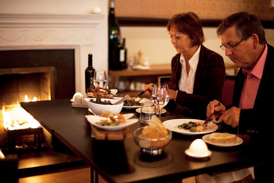 En mann og en dame som spiser ved en peis.