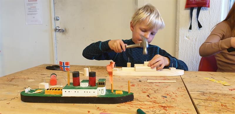 Et barn bygger båt