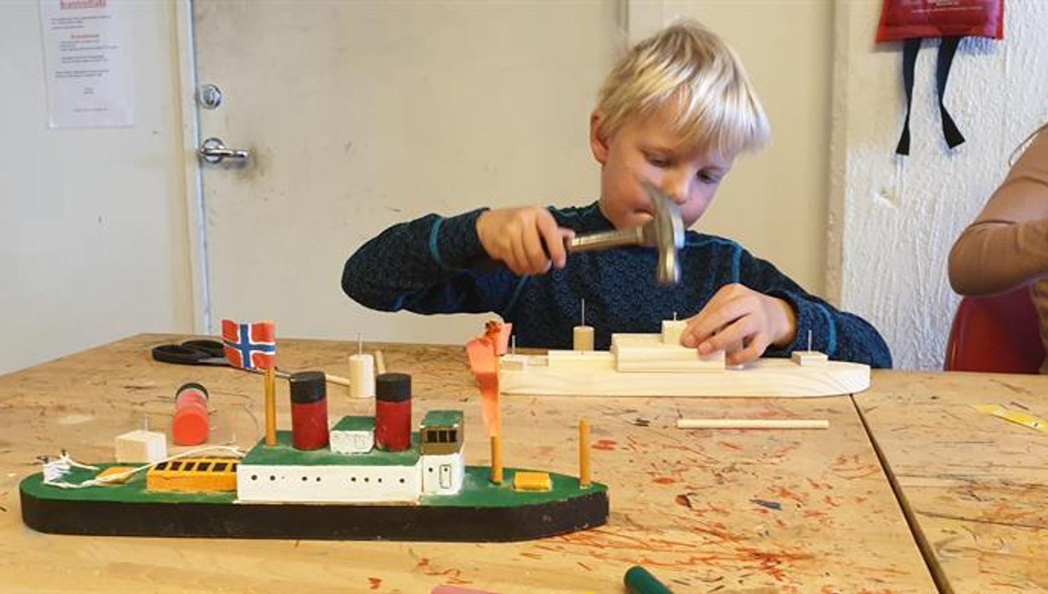 Et barn bygger båt