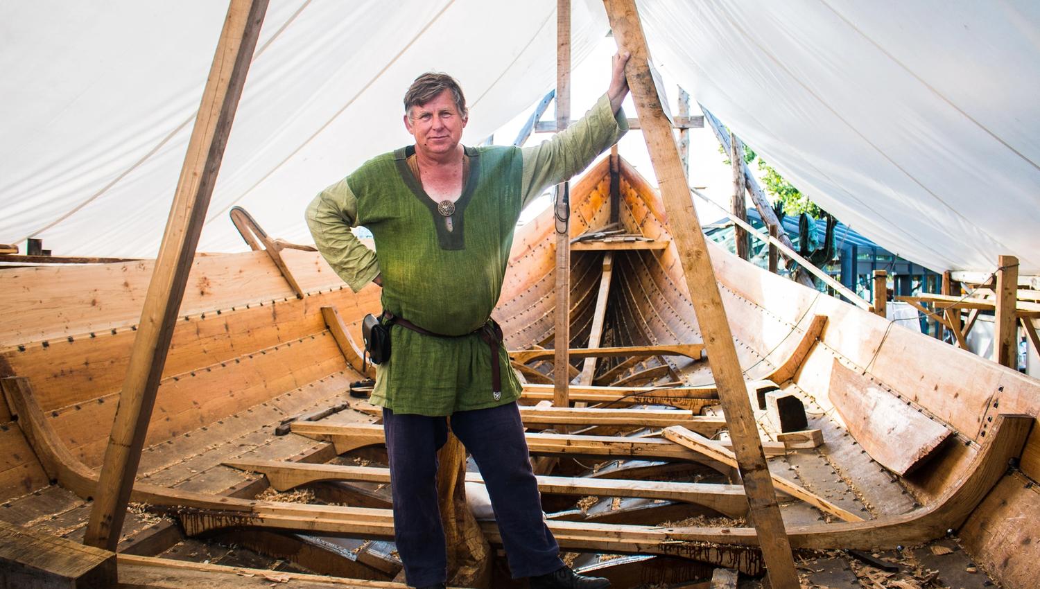 Bilde av en mann i vikingklær oppi vikingskipet saga farmann mens det var under bygging