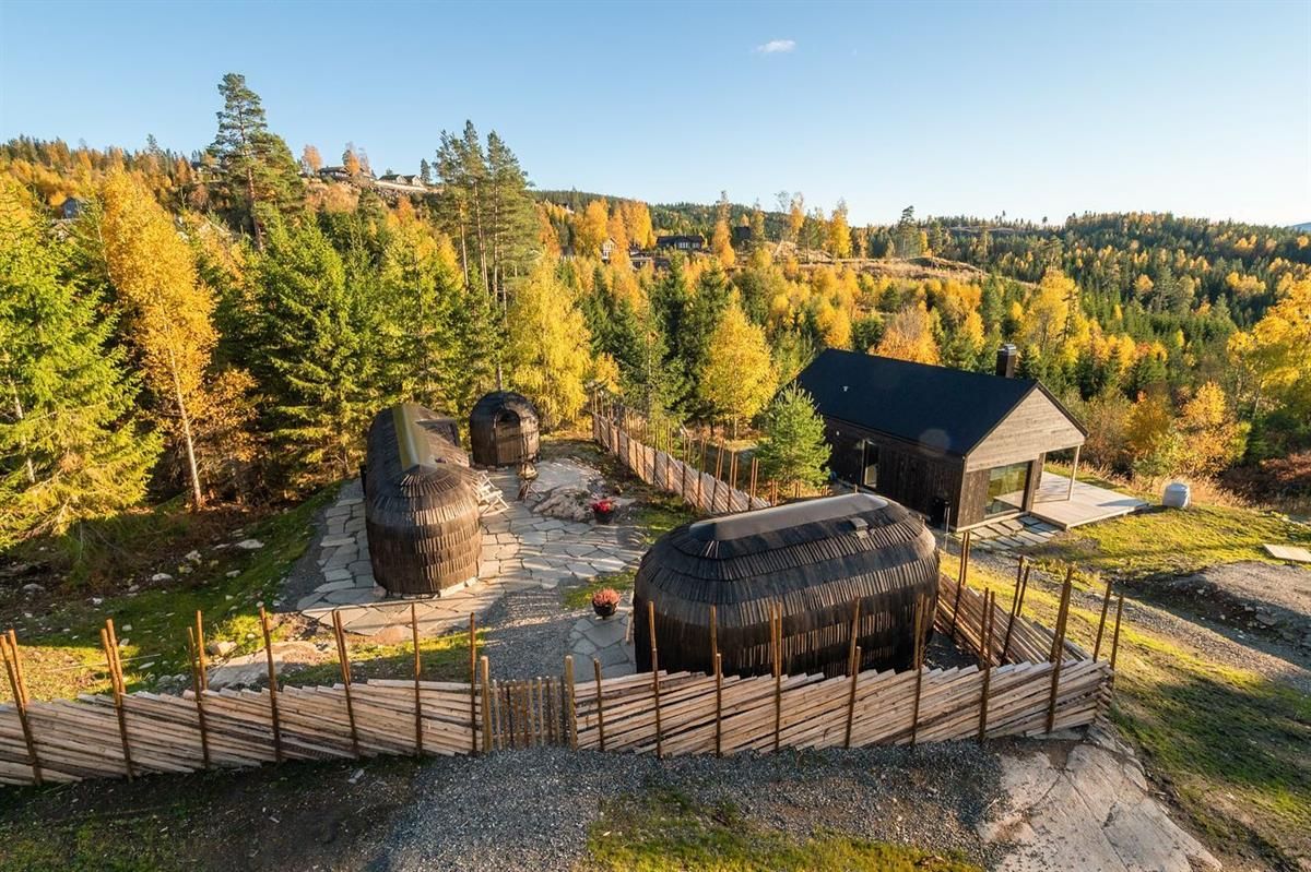 Cabin area with wooden pod cabins surrounded by autumn-colored trees.