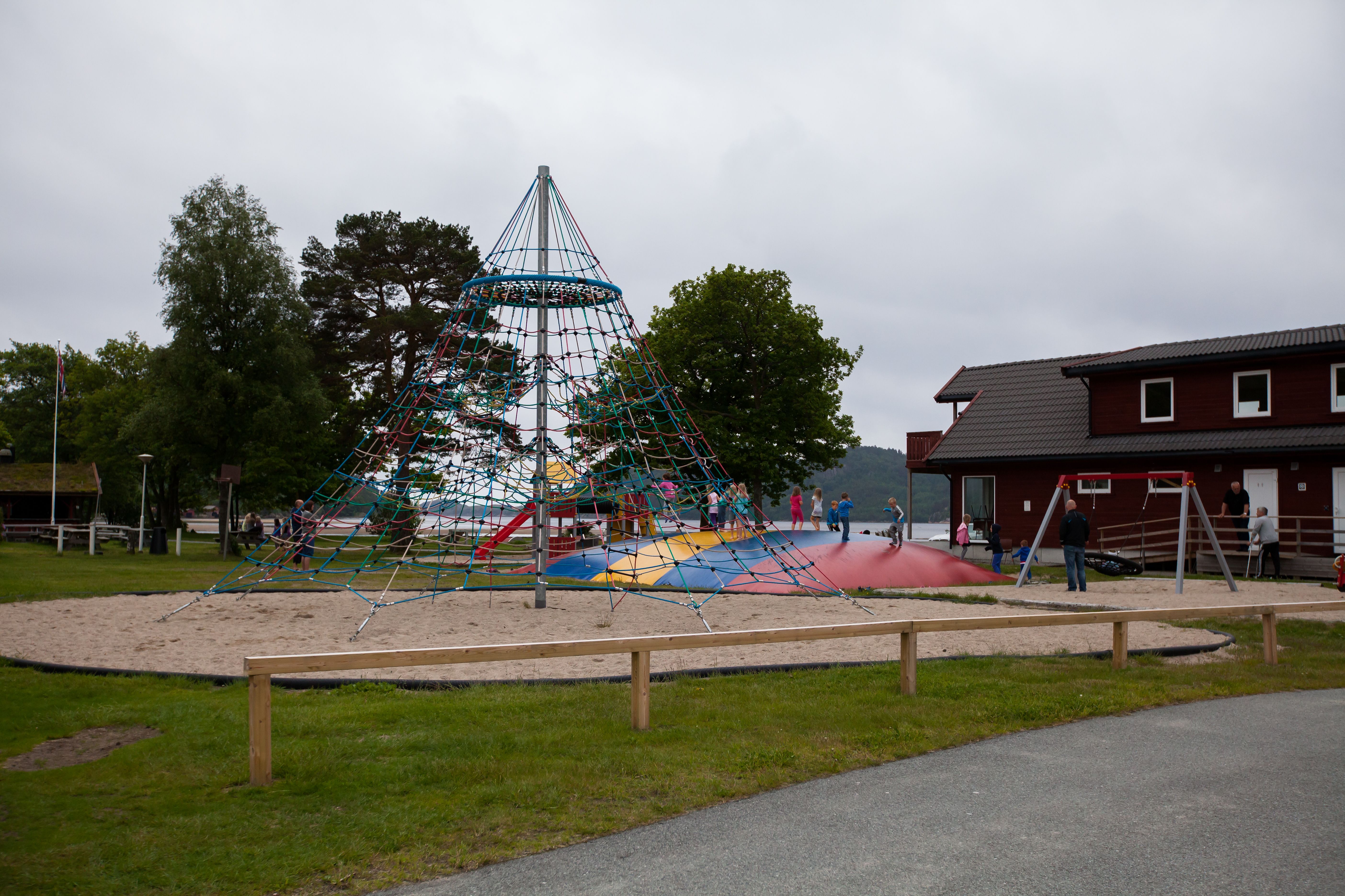 Solstrand Camping playground. A climbing tower in the center and a colorful jumping pillow beside it.